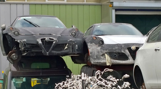 A pair of Alfa Romeo 4Cs at an Italian wrecker's yard